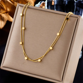 Colar Dualis Verzano – colar feminino de aço inoxidável 316L com correntes cubanas duplas, acessório moderno e sofisticado disponível em dourado e prateado.