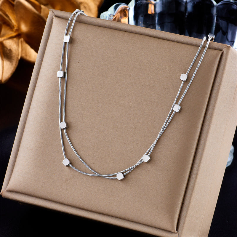 Colar Dualis Verzano – colar feminino de aço inoxidável 316L com correntes cubanas duplas, acessório moderno e sofisticado disponível em dourado e prateado.
