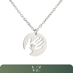 Colar Verzano® com pingente redondo em aço inoxidável representando duas mãos entrelaçadas, disponível em dourado e prateado — joia afetiva e sofisticada para presentes especiais.
