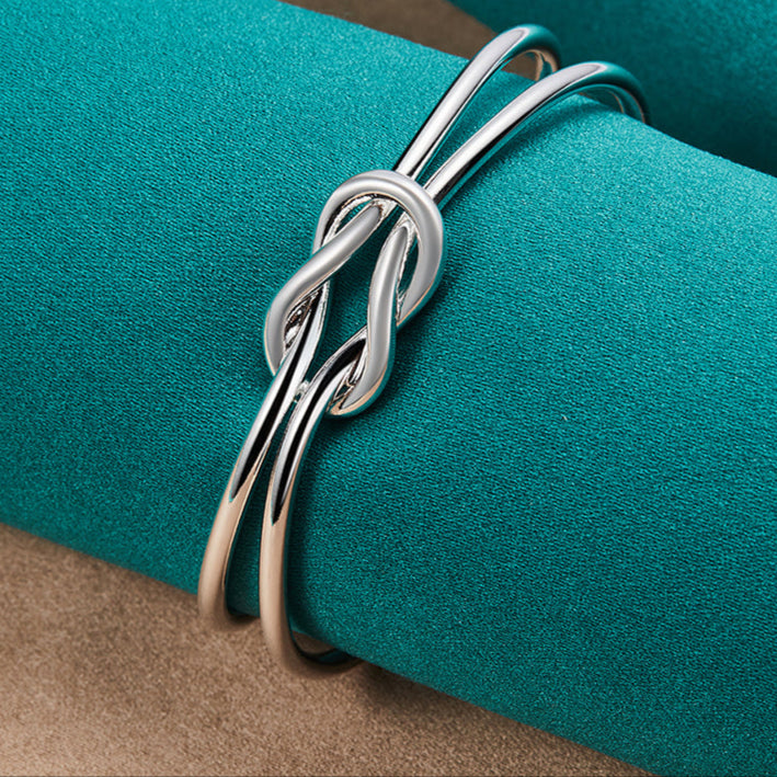 Bracelete Entrelace Verzano® em prata esterlina 925, design geométrico entrelaçado, ajustável, unissex, elegante e sofisticado.